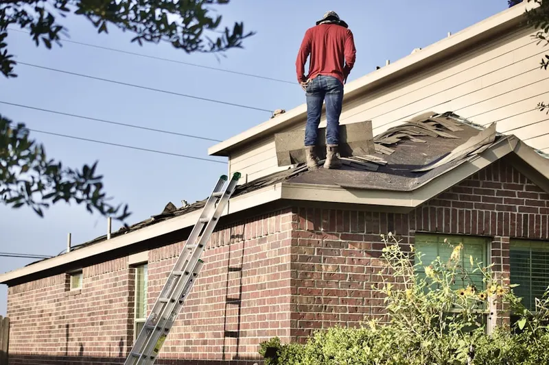 Professional roofer working on a residential roof in Valley Stream Estates